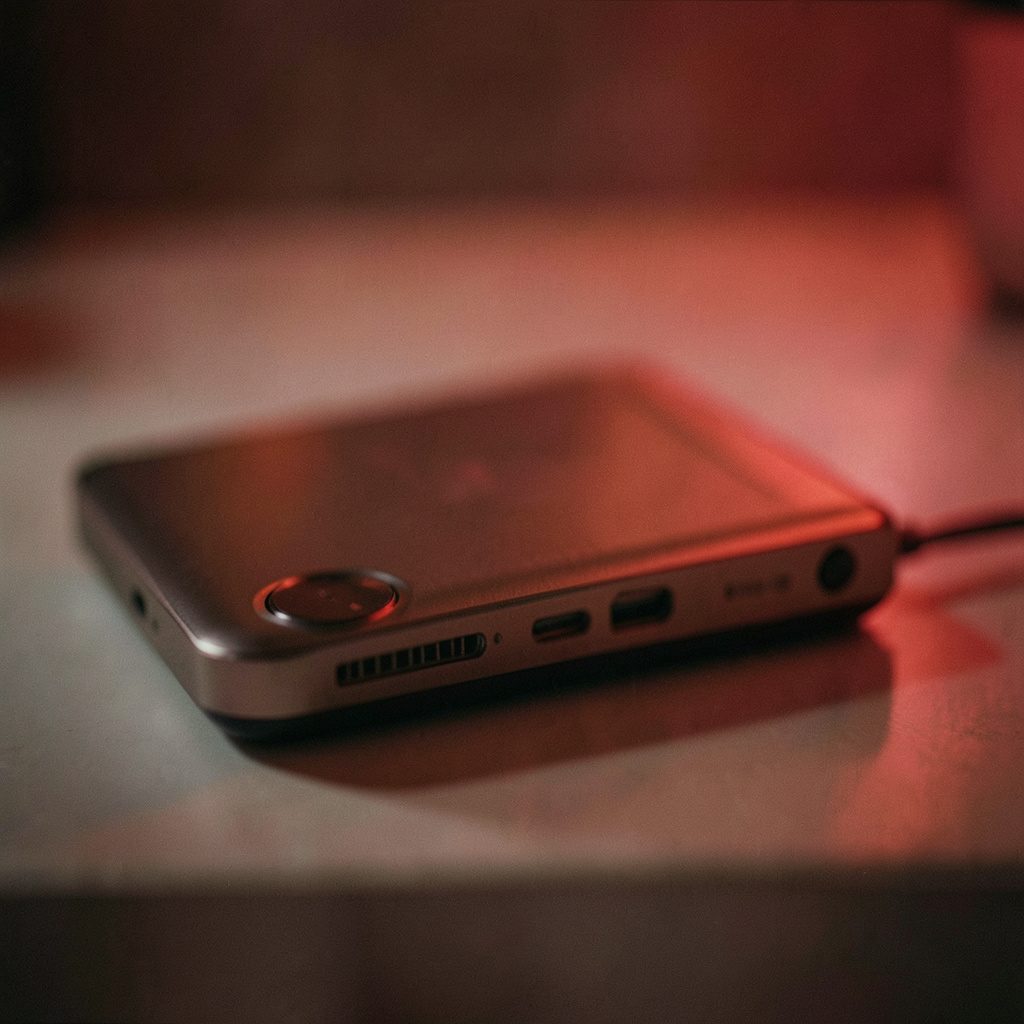 A sleek laptop resting on a desk in a calm, minimal workspace with soft blue-gray lighting and shallow depth of field